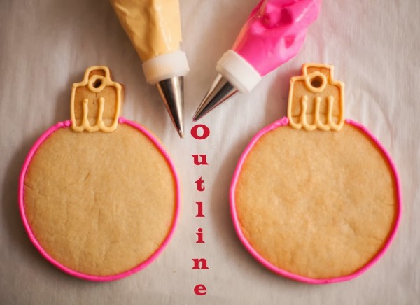 decorated pink christmas ornament cookies with fondnt snowflake