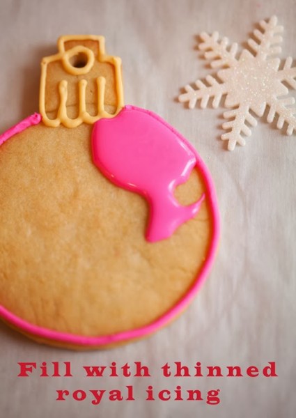 decorated pink christmas ornament cookies with fondnt snowflake