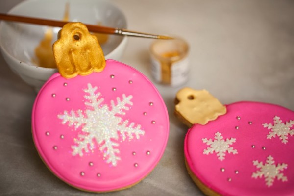 decorated pink christmas ornament cookies with fondnt snowflake